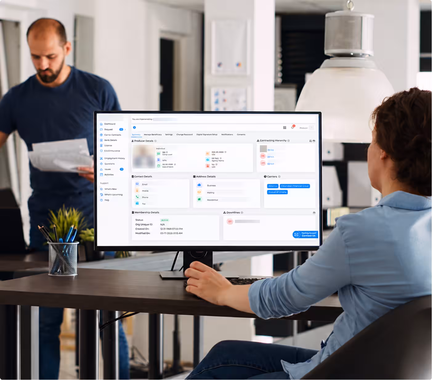 Team reviewing producer records on a desktop dashboard